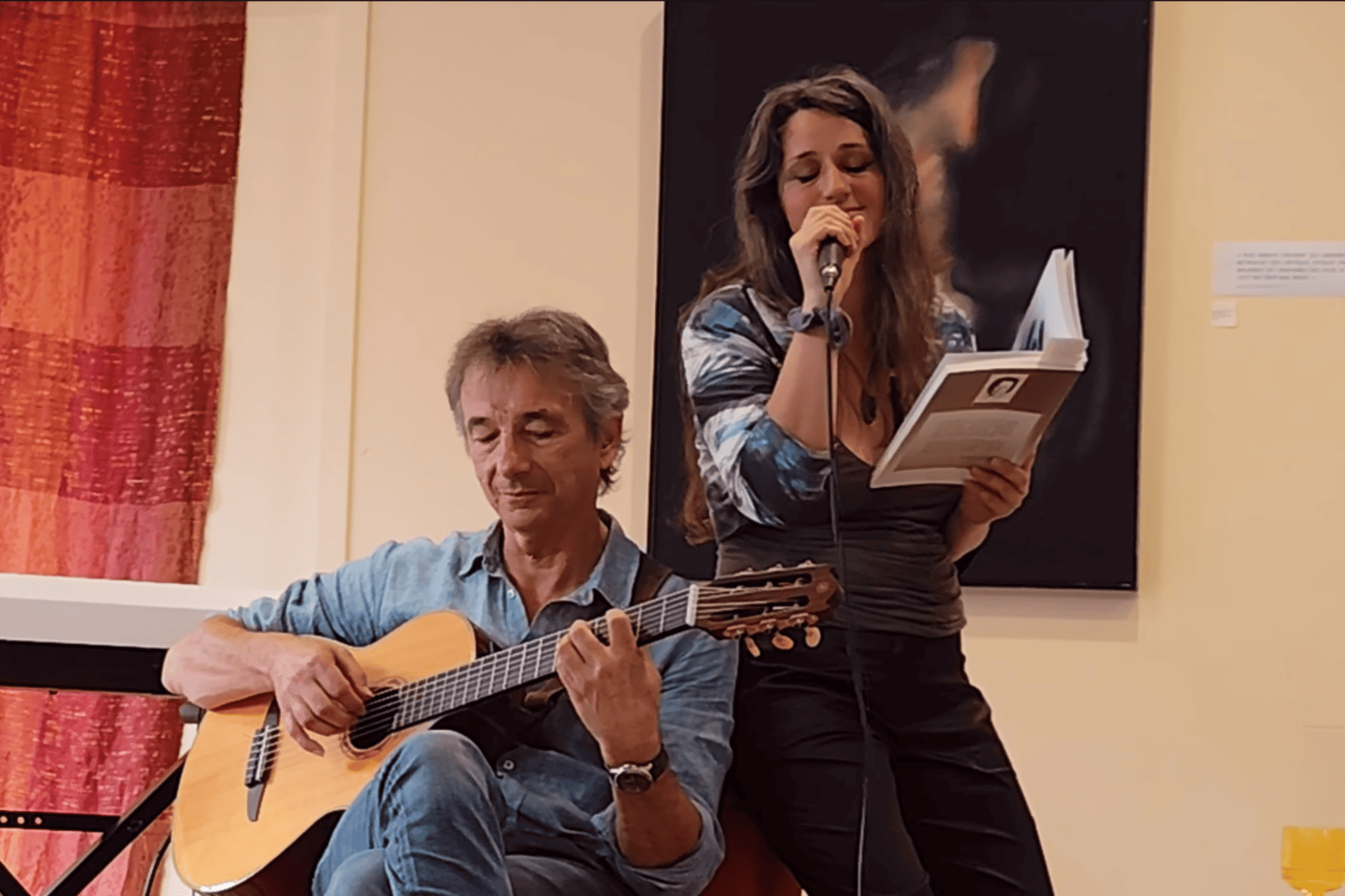 Emilie Souillot avec son micro, un livre, et un guitariste